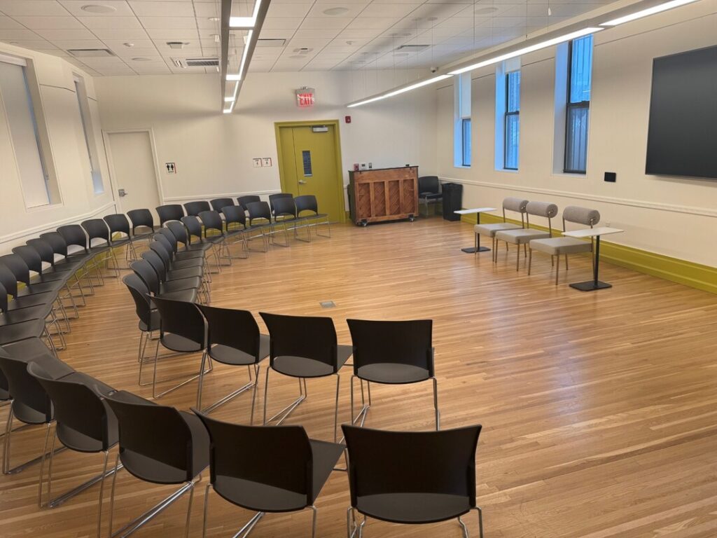 Studio on 4 at Middle Church arranged in a fireside chat layout, with chairs curved in a semicircle facing lounge seating and a wall-mounted screen